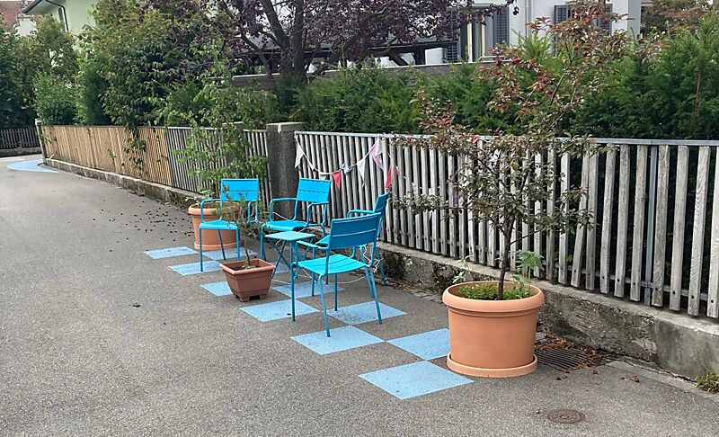 Beispiel Begegnungszone in Aarau, Buchenweg 1. Zwei blaue Stühle auf einer blau markieren Fläche.